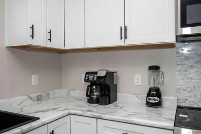 a kitchen with white cabinets and a coffee maker on a counter at The Restful Ark in Crittenden