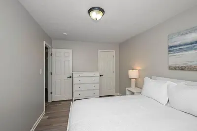 a bedroom with a white bed and a dresser at The Restful Ark in Crittenden