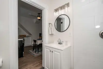 a white bathroom with a sink and a mirror at Historic Ludlow Suites - 2 Apts in Ludlow
