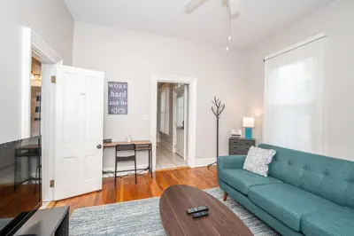 a living room with a blue couch and a table at Hackberry Retreat 1 Close to Downtown in Cincinnati