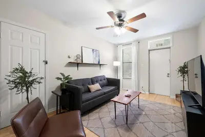 a living room with a couch and a ceiling fan at The Luxe Pearl Residences in Columbus