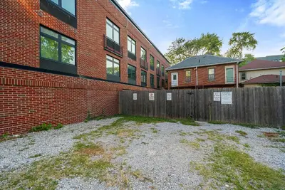 a brick building with a wooden fence in front of it at The Luxe Pearl Residences in Columbus
