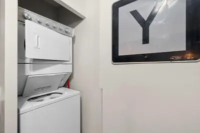 a kitchen with a washer and dryer next to a refrigerator at The Luxe Pearl Residences in Columbus