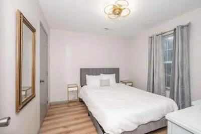 a white bedroom with a bed and a window at Arkstone Retreat 1 - Chic Downtown Escape in Williamstown
