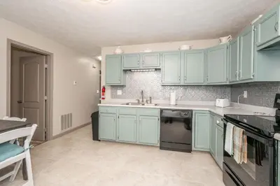 a kitchen with green cabinets and a sink at Arkstone Retreat 2 - Chic 2 Bedroom in Williamstown