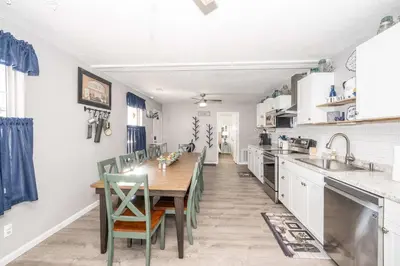 a kitchen with a wooden table and green chairs at Arkstone Retreat 3 in Williamstown