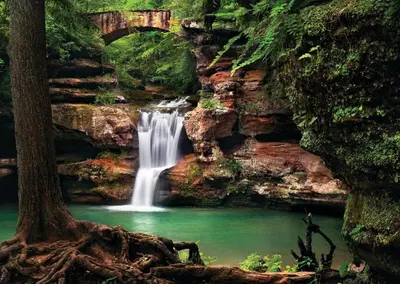 a waterfall with a bridge and a pool of water at Mill Haus in South Bloomingville