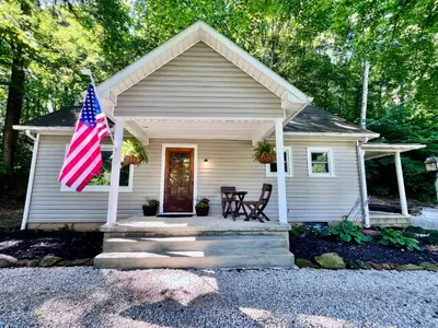 a small house with an american flag in front of it at Mill Haus in South Bloomingville