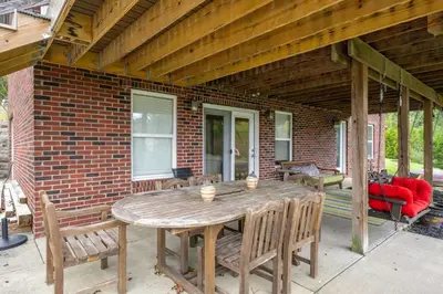 a wooden table and chairs on a patio at Lazy Days Waterfront for 12 in Williamstown