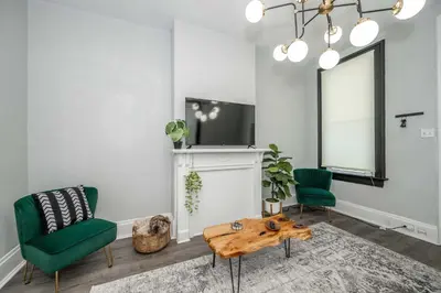 a living room with two green chairs and a table at Chic Modern Gem with Style in Cincinnati
