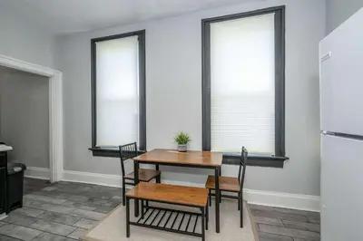 a dining room with a table and chairs and two windows at Chic Modern Gem with Style in Cincinnati