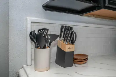 two containers of kitchen utensils sitting on a counter at Chic Modern Gem with Style in Cincinnati