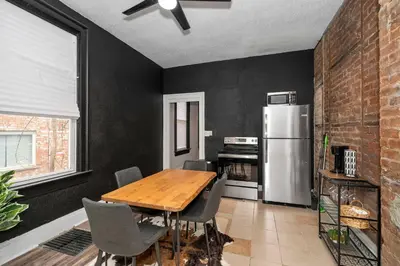 a kitchen with a wooden table and a refrigerator at Chic Modern Gem with Style Suites in Cincinnati