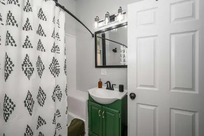 a bathroom with a green cabinet and a sink at Chic Modern Gem with Style Suites in Cincinnati