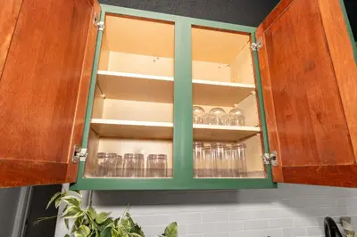 a green cabinet with glasses in it in a kitchen at Stylish Modern Gem in the HIlls in Cincinnati