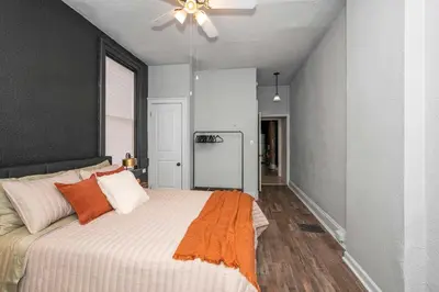 a bedroom with a bed with an orange blanket at Stylish Modern Gem in the HIlls in Cincinnati