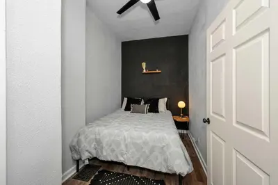 a bedroom with a bed and a black wall at Stylish Modern Gem in the HIlls in Cincinnati