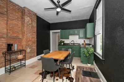 a kitchen with green cabinets and a wooden table at Stylish Modern Gem in the HIlls in Cincinnati
