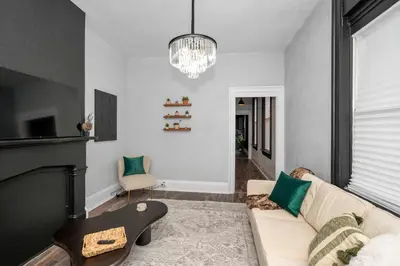 a living room with a couch and a chandelier at Stylish Modern Gem in the HIlls in Cincinnati