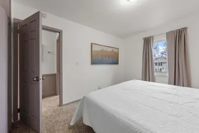 a white bedroom with a bed and a window at The Gahanna Getaway in Columbus