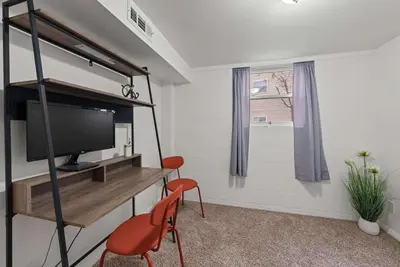 a room with a tv and a chair and a desk at The Gahanna Getaway in Columbus