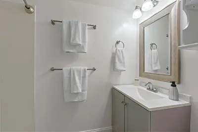 a white bathroom with a sink and a mirror at The Gahanna Getaway in Columbus