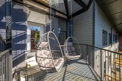 two swings on a porch with a stuffed bear in them at Queen City Views Suites in Cincinnati