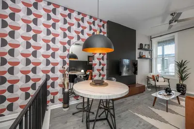 a living room with a table and a patterned wall at Queen City Views Suites in Cincinnati