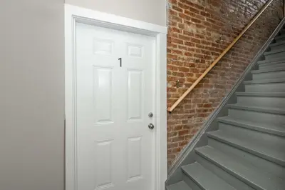 a white door next to a brick wall at Queen City Views 1 Chic 1 BDR in Cincinnati