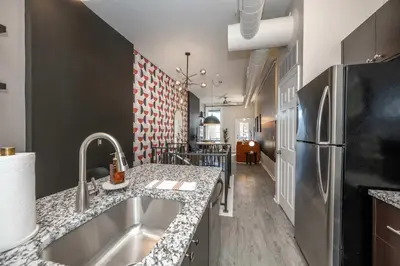 a kitchen with a sink and a refrigerator at Queen City Views 1 Chic 1 BDR in Cincinnati