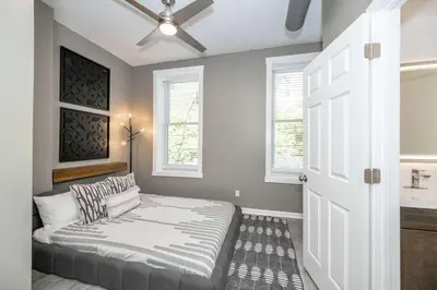 a room with a bed and a sink and windows at Queen City Views 3 Chic 2 BDR in Cincinnati