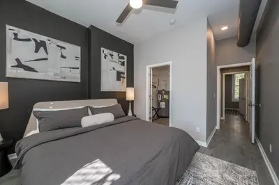 a bedroom with a large bed with gray walls at Queen City Views 3 Chic 2 BDR in Cincinnati