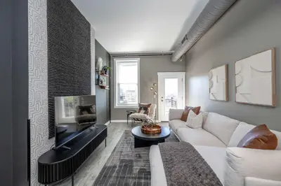 a living room with a couch and a fireplace at Queen City Views 4 Chic Apt in Cincinnati