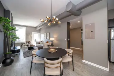 a dining room and living room with a table and chairs at Queen City Views 4 Chic Apt in Cincinnati