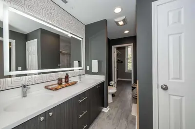 a bathroom with two sinks and a mirror at Queen City Views 4 Chic Apt in Cincinnati