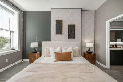 a bedroom with a large white bed with two lamps at Queen City Views 4 Chic Apt in Cincinnati