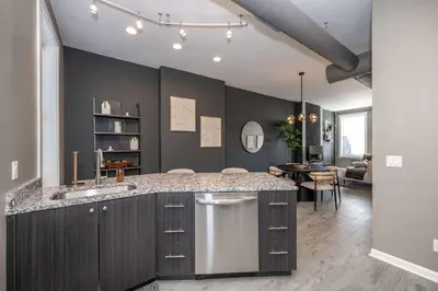 a kitchen with a counter and a dining room at Queen City Views 4 Chic Apt in Cincinnati