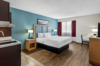 a hotel room with a bed and a kitchen at Suburban Studios Charleston - Civic Center in Charleston