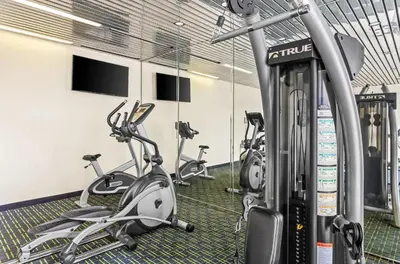 a gym with several exercise bikes in a room at Suburban Studios Charleston - Civic Center in Charleston