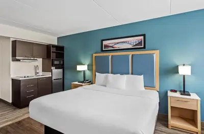 a hotel room with a large bed and a kitchen at Suburban Studios Charleston - Civic Center in Charleston