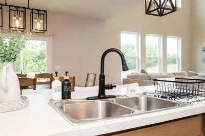 a kitchen with a stainless steel sink and a living room at Lunar Haven - Gorgeous 5 BDR in Walton