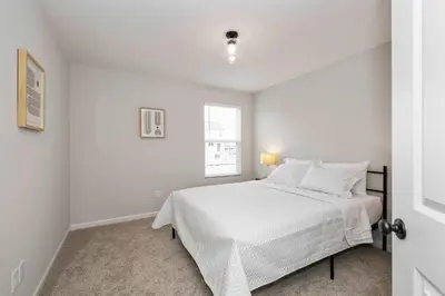 a white bedroom with a bed and a window at Lunar Haven - Gorgeous 5 BDR in Walton