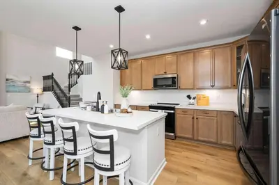 a kitchen with a white counter top and wooden cabinets at Lunar Haven - Gorgeous 5 BDR in Walton
