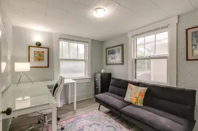 a living room with a couch and a desk and windows at 3 Mi to Dtwn Dog-Friendly Retreat in Dayton in Dayton