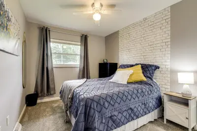 a bedroom with a bed and a brick wall at 10 Mi to Dtwn Cincinnati Home with Patio and Yard! in Cincinnati