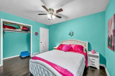 a bedroom with blue walls and a bed with pink pillows at Little Paris- In Affluent University HTS in University Heights