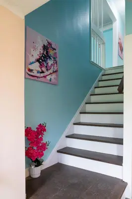 a staircase in a house with a painting on the wall at Little Paris- In Affluent University HTS in University Heights