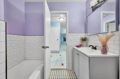 a bathroom with a white tub and a sink at Little Paris- In Affluent University HTS in University Heights