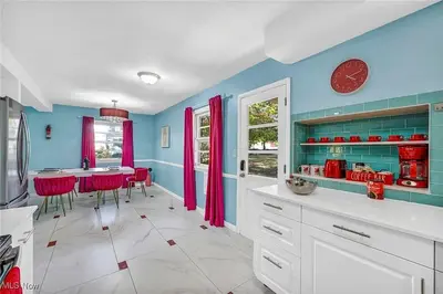 a kitchen with red and blue walls and a table at Little Paris- In Affluent University HTS in University Heights