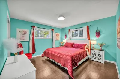 a bedroom with blue walls and a bed with a red bedspread at Little Paris- In Affluent University HTS in University Heights